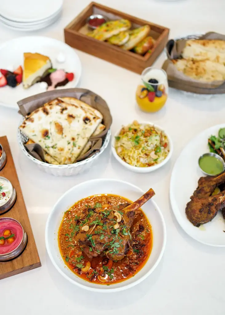 Indian curry served with naan, rice, desserts, and shared dishes at Central by Saffron Valley.
